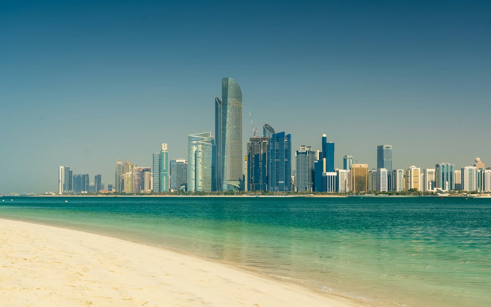 Mobile crane working on an infrastructure project against the Abu Dhabi skyline